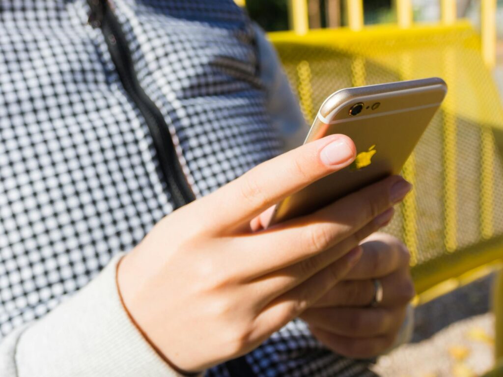 A photo of a person checking their phone for show updates, representing social media engagement. — discount show tickets…