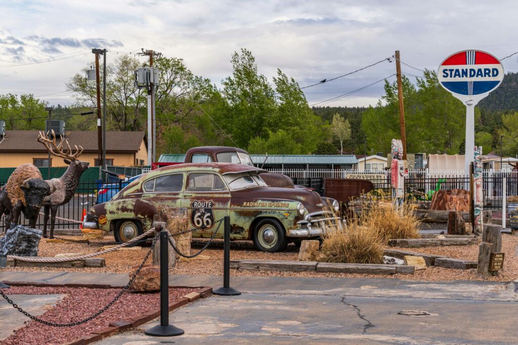 A vintage Route 66 sign with classic cars in the background — day trips from Las Vegas