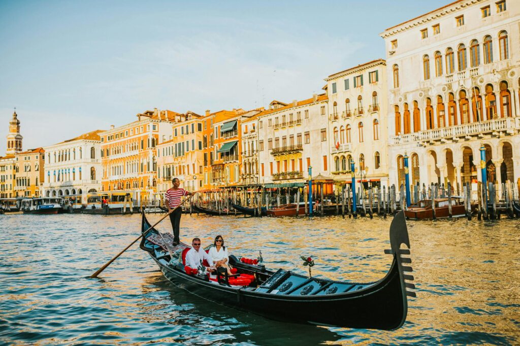 Couples enjoying a gondola ride at The Venetian with the sunset in the background. — romantic things to do in Las Vegas