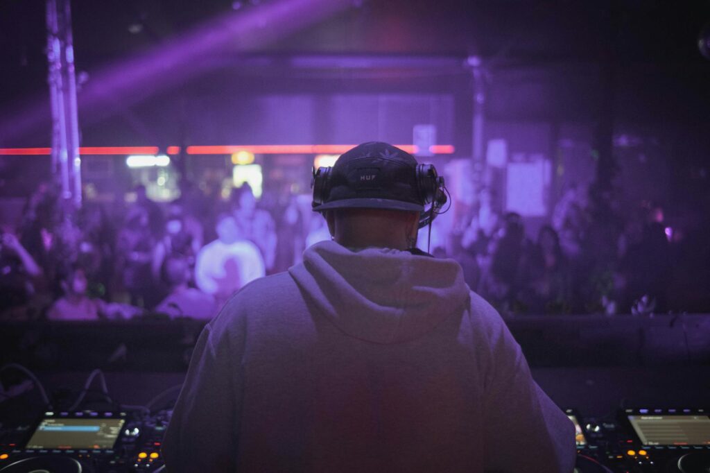 A DJ performing at one of the best nightclubs in Vegas with party-goers dancing. — Las Vegas nightlife