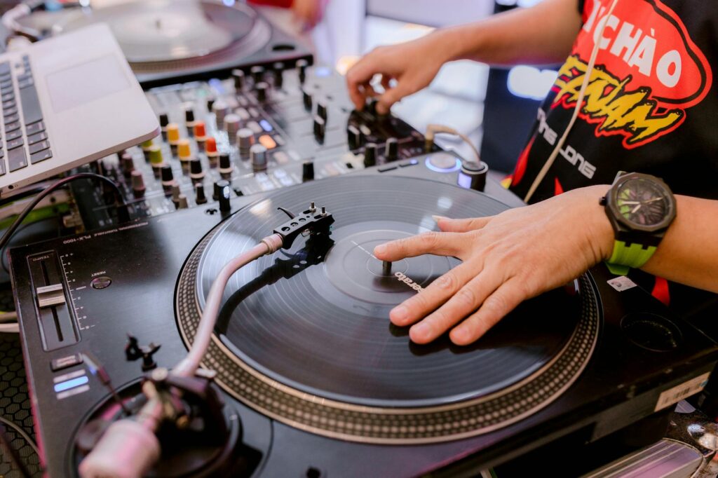 A DJ spinning records at a Las Vegas club, with a lively crowd in the background. — Las Vegas nightlife clubs