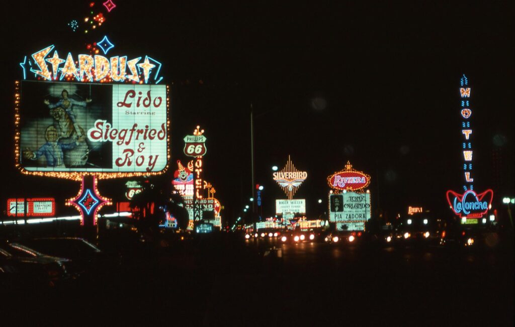A bustling Las Vegas Strip with numerous show billboards — discount show tickets Las Vegas