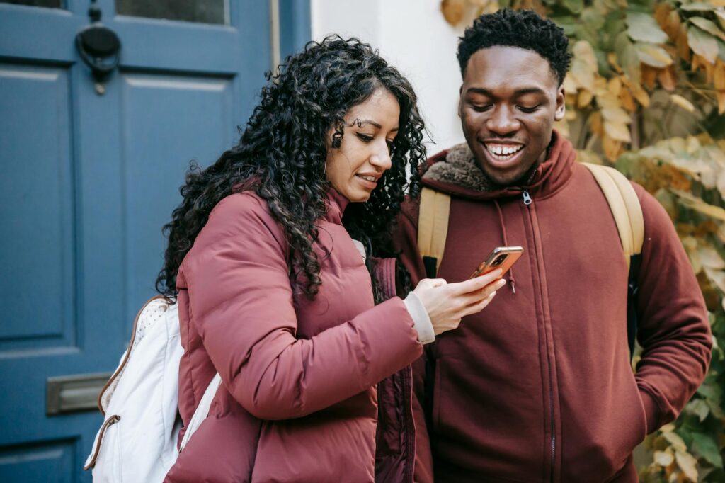A couple checking their phone for last-minute hotel deals in Las Vegas. — Las Vegas hotel deals