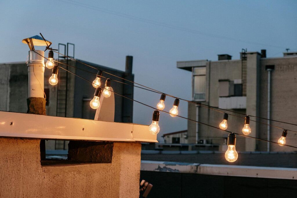 A cozy seating area at a rooftop bar, illuminated by string lights. — rooftop bars Las Vegas