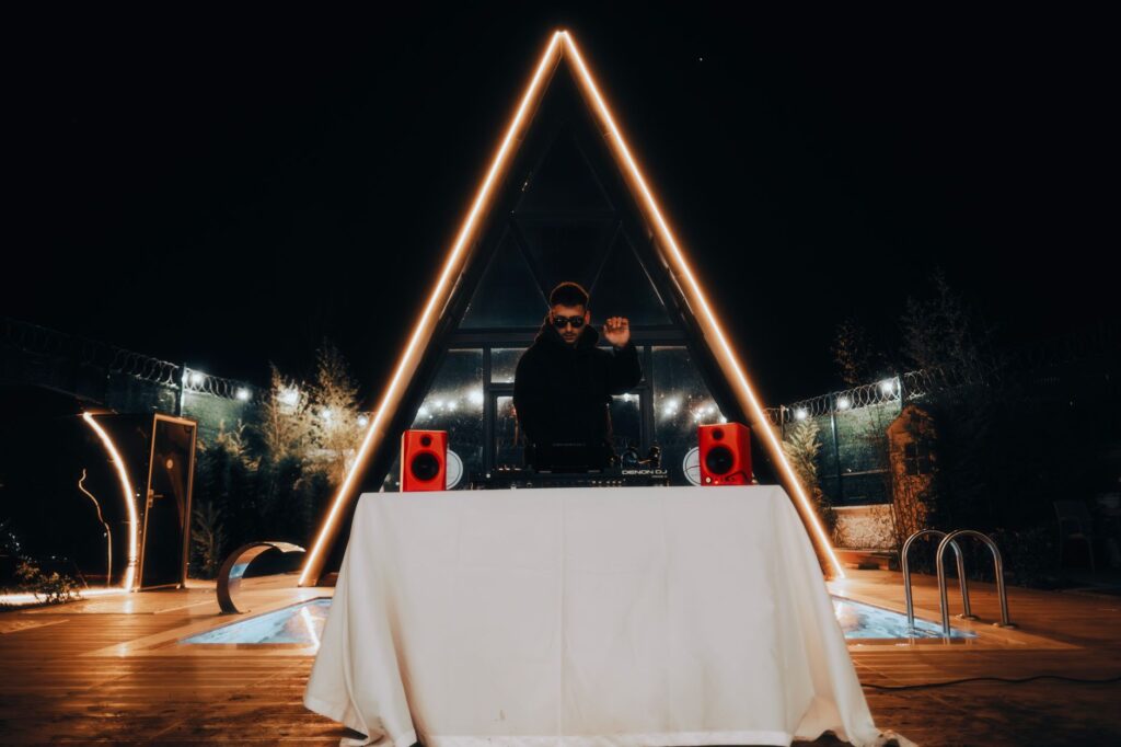 A DJ performing live at a lively Vegas pool party, with a crowd dancing around the pool. — Vegas pool parties 2026
