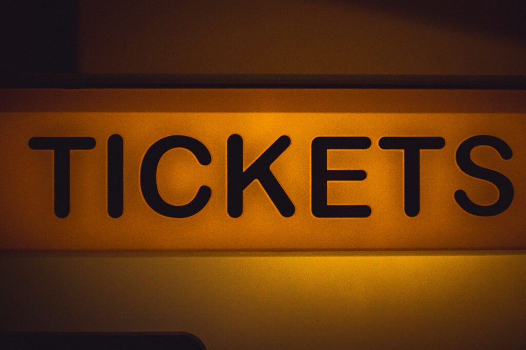 A bustling ticket booth in Las Vegas with signs advertising discounted show tickets. — discounted show tickets Las Vegas