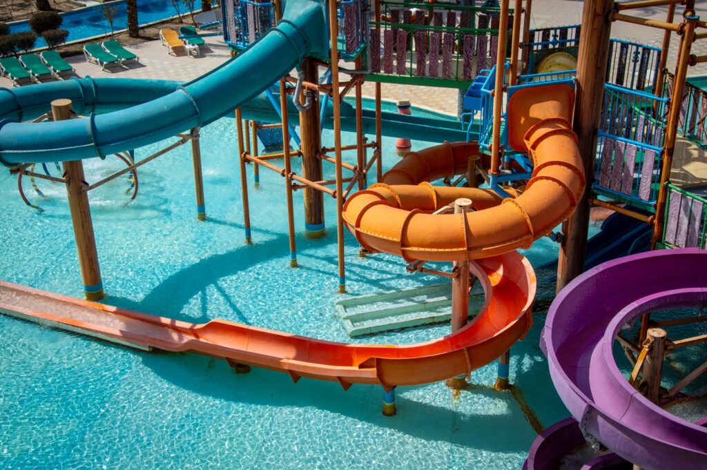 A family enjoying a day at a Las Vegas water park, with colorful slides and pools in the background. — family activities…