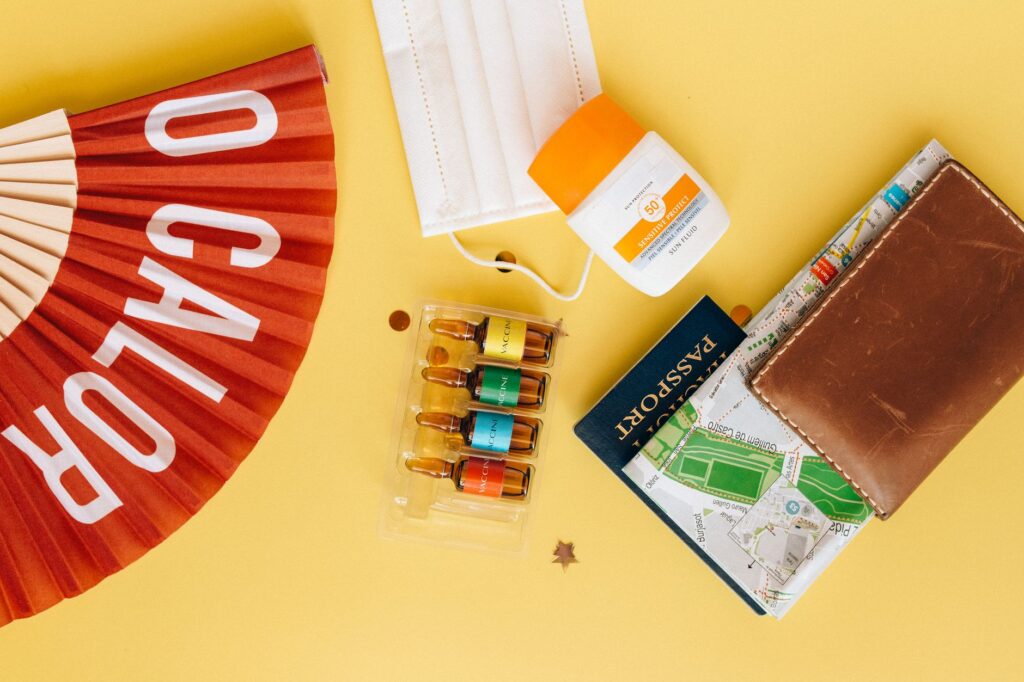 A flat lay of travel essentials, including sunscreen, water bottles, and IDs. — packing list for Las Vegas summer