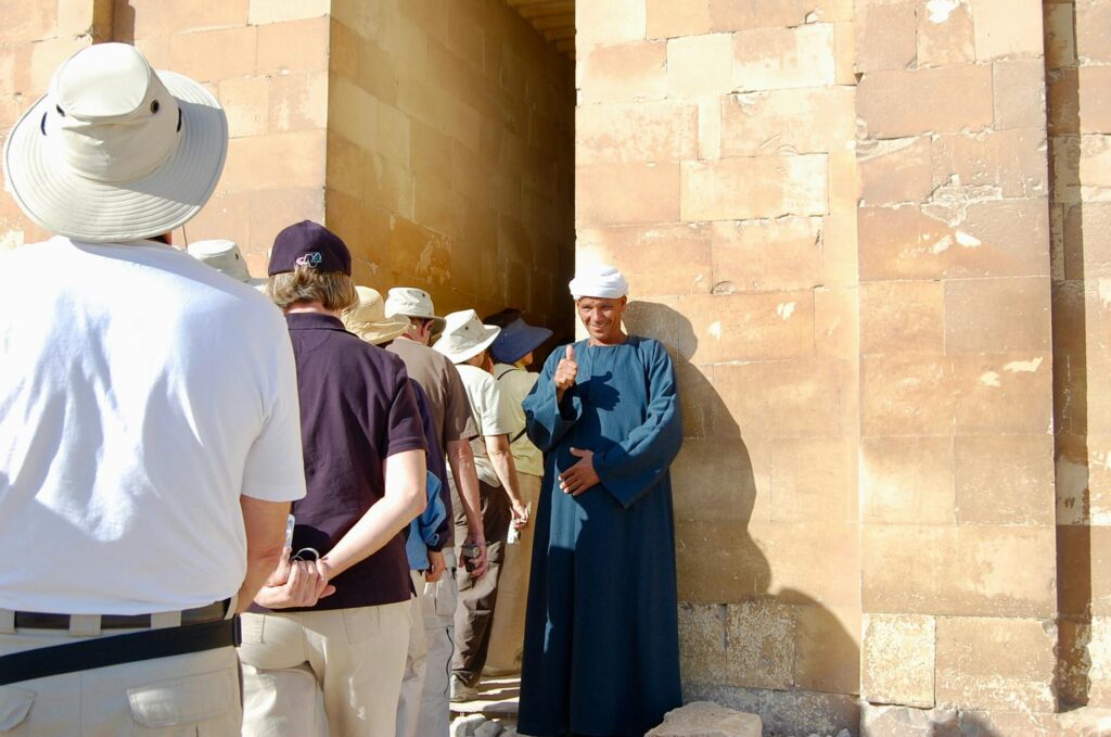 A friendly guide giving advice to a group of first-time visitors in front of a famous landmark. — first time visiting La…