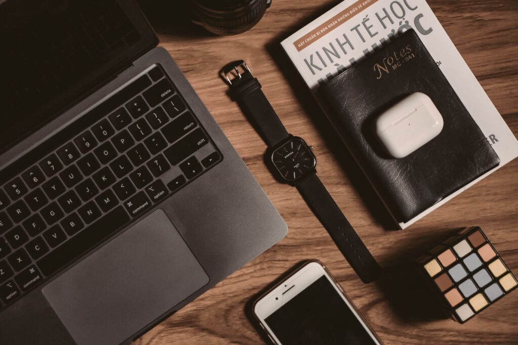 A laptop and phone on a table with Vegas-themed items around. — las vegas packing list