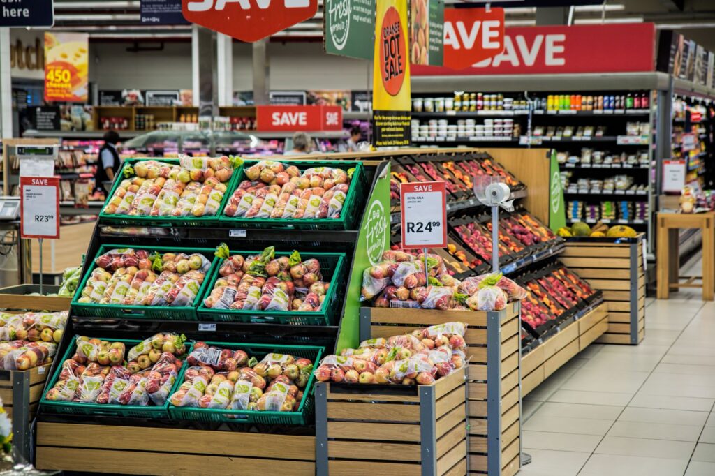A snapshot of a grocery store aisle filled with fresh produce, indicating where travelers can buy ingredients to prepare m…