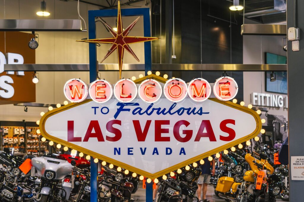 A traveler taking a photo in front of the famous Welcome to Fabulous Las Vegas sign. These Vegas vacation tips enhance your quick visit.