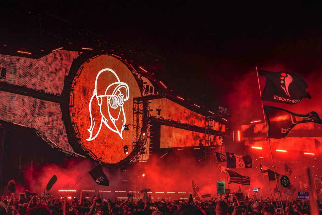 A vibrant crowd enjoying a music festival in Las Vegas with colorful lights and energetic performers. — Las Vegas summer…