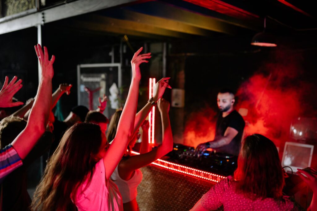 Guests dancing and enjoying the atmosphere at a pool party, with a DJ booth in the background. — las vegas pool parties