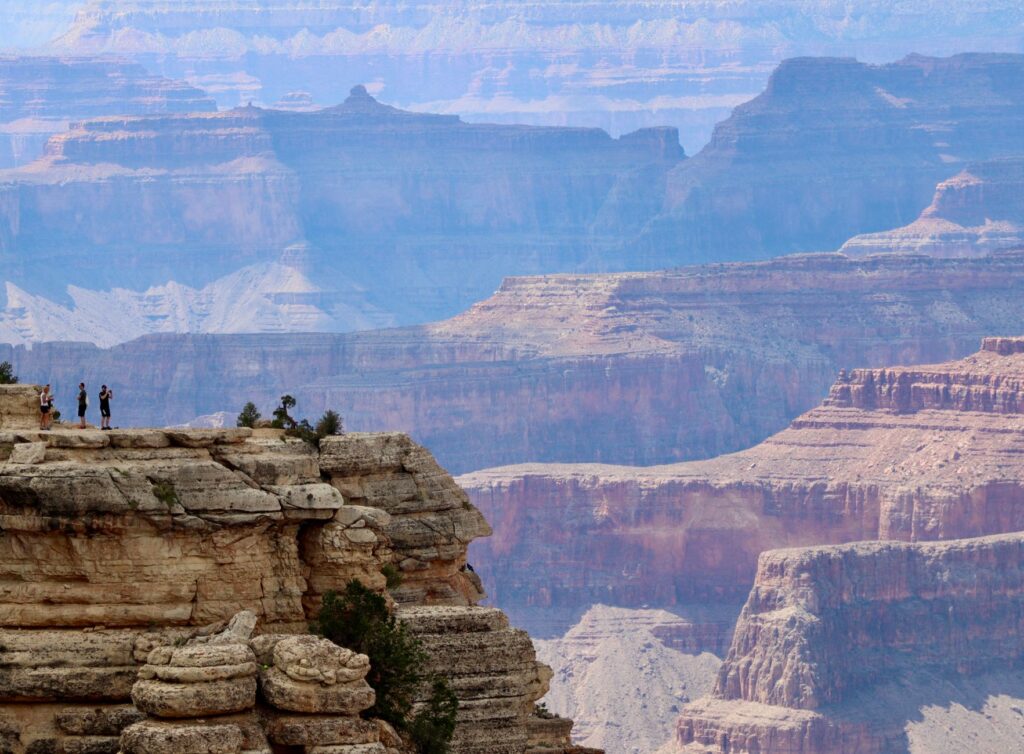Tourists enjoying a scenic bus ride with the Grand Canyon in the background. — grand canyon vegas tour