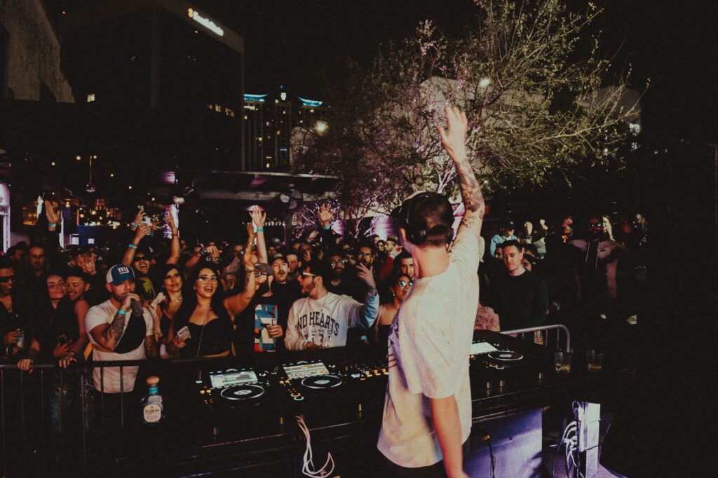 A DJ performing live at a Las Vegas pool party with a lively crowd. — Las Vegas pool parties