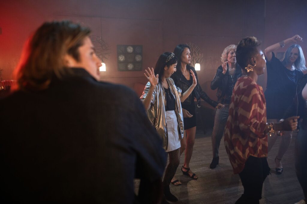 A group of friends dancing in an energetic Las Vegas club, highlighting the fun atmosphere. — Las Vegas nightlife budget