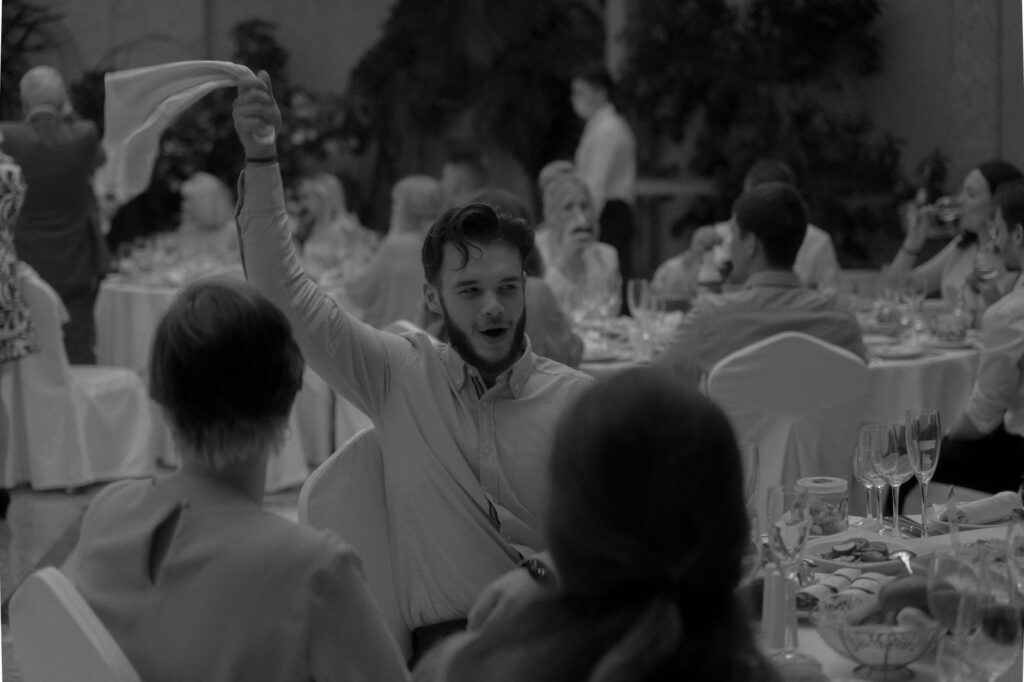 A lively scene of diners enjoying an interactive dining experience with entertainment in the background. — unique dining…