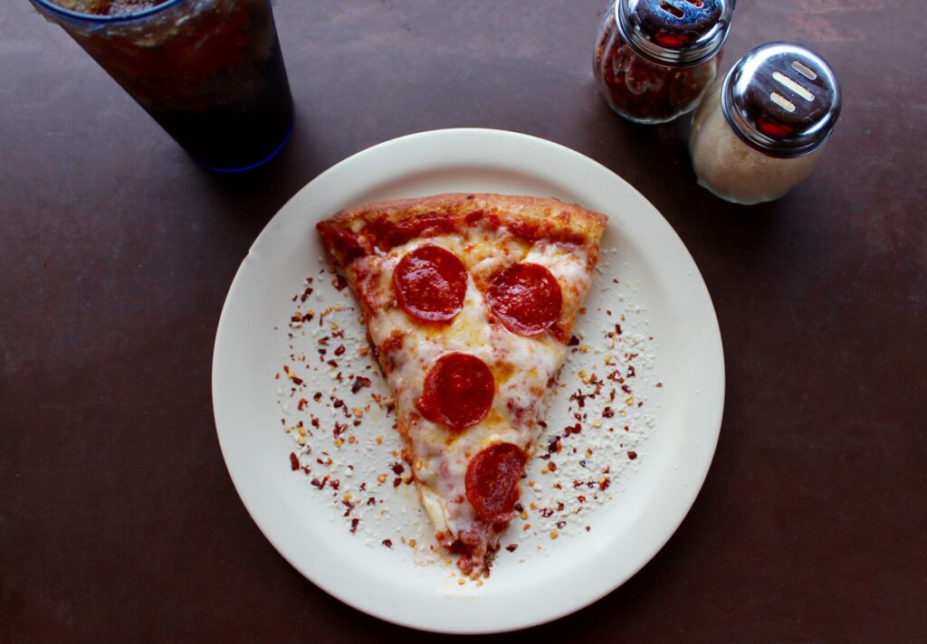 A slice of pizza from Secret Pizza, highlighting its unique atmosphere. — unique experiences in Las Vegas