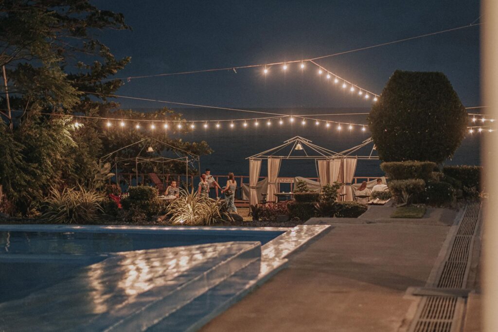 A sunset view of a Las Vegas pool party, with twinkling lights and lively guests enjoying the atmosphere. — Las Vegas po…