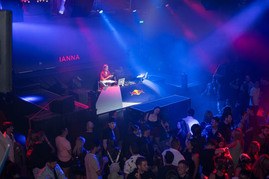 An aerial view of a packed nightclub with a DJ booth and colorful lights. — Las Vegas nightclubs guide