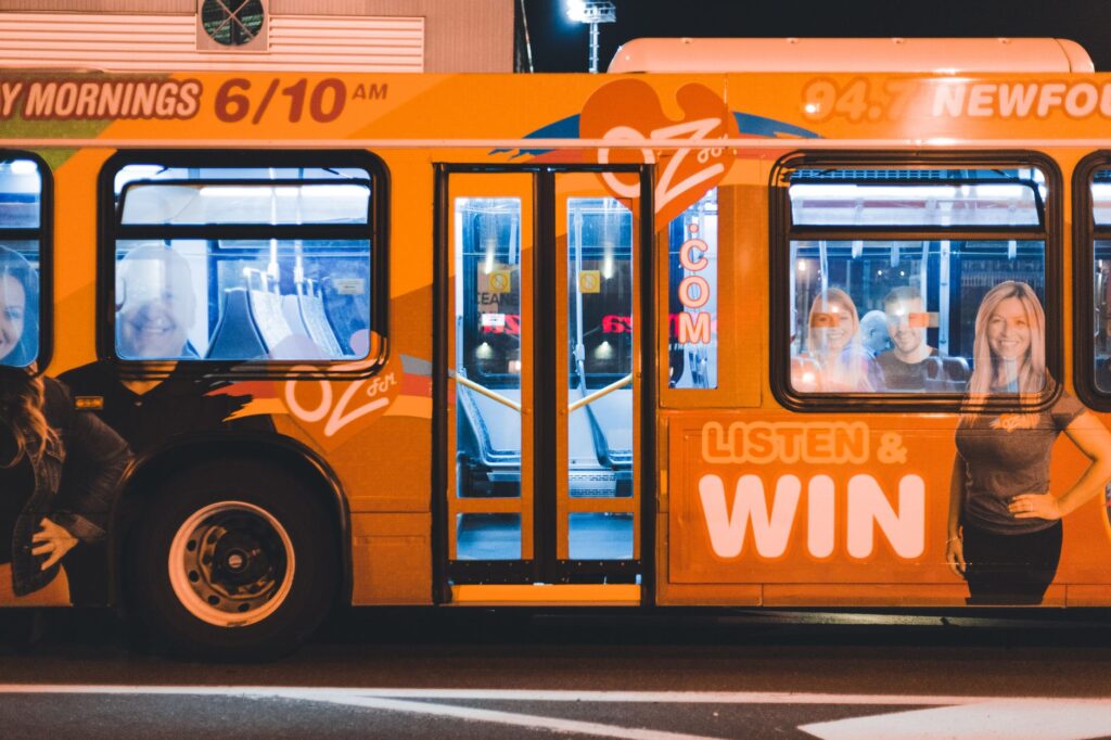 A Deuce bus making a stop with the Strip's neon lights in the background. — Las Vegas transportation guide