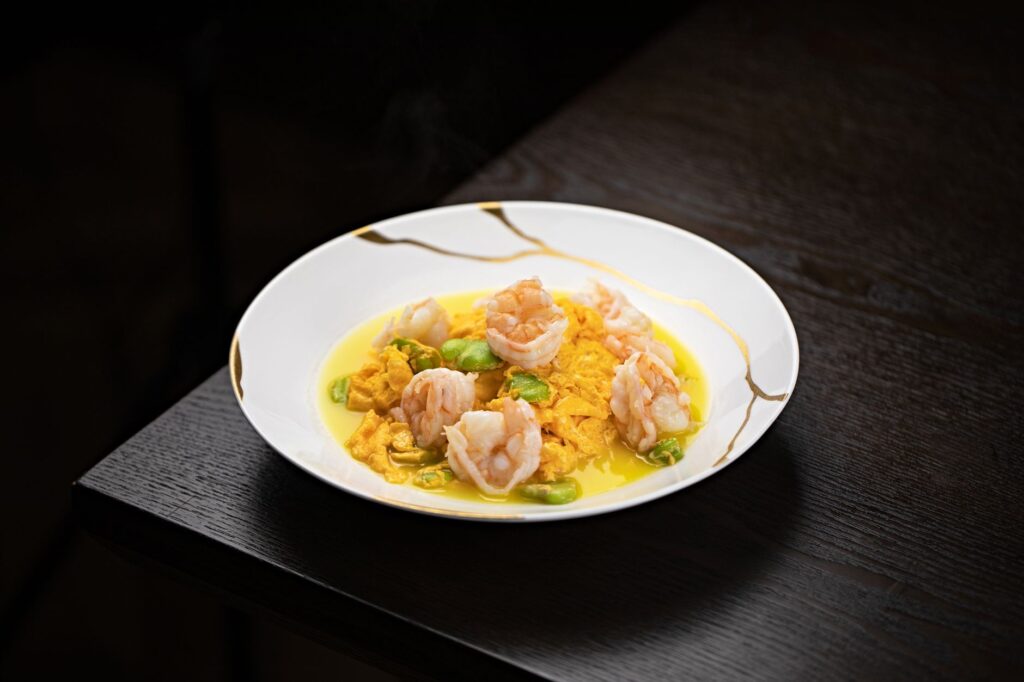 A beautifully plated dish served in a dark dining environment, showcasing the concept of unique dining Las Vegas.
