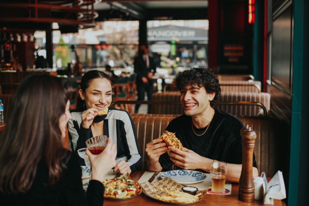 A group of friends enjoying a meal at a recommended restaurant off the Strip. — dining off the strip Las Vegas