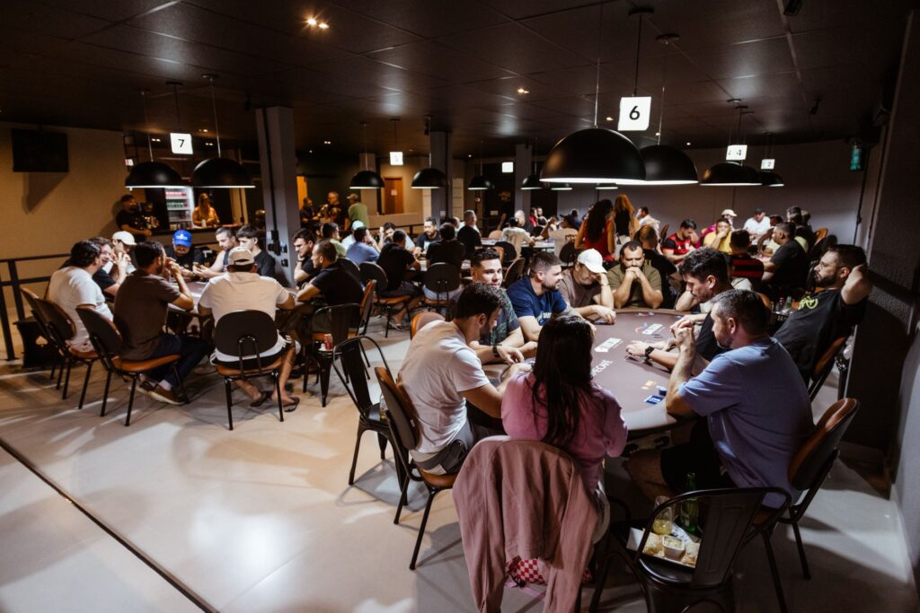 A group of friends laughing and enjoying Vegas casino drinks at a gaming table. — free drinks gambling Vegas