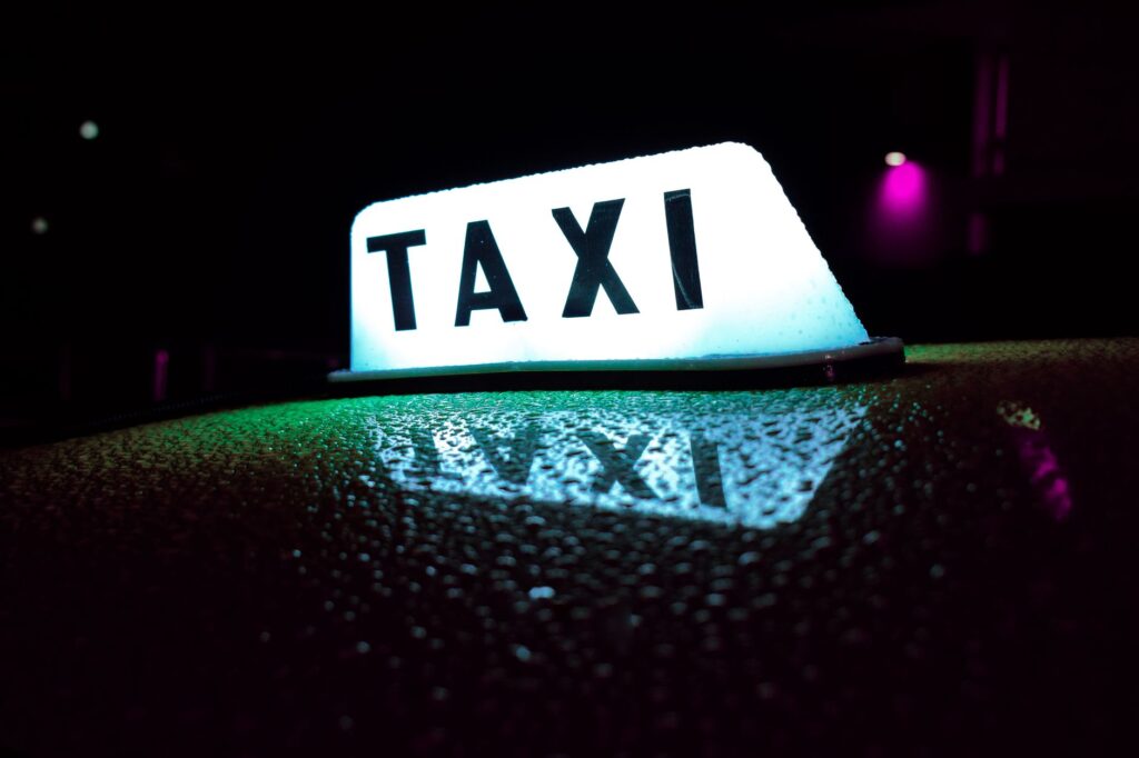 A taxi cab on the Las Vegas Strip with neon lights in the background. — transportation in Las Vegas