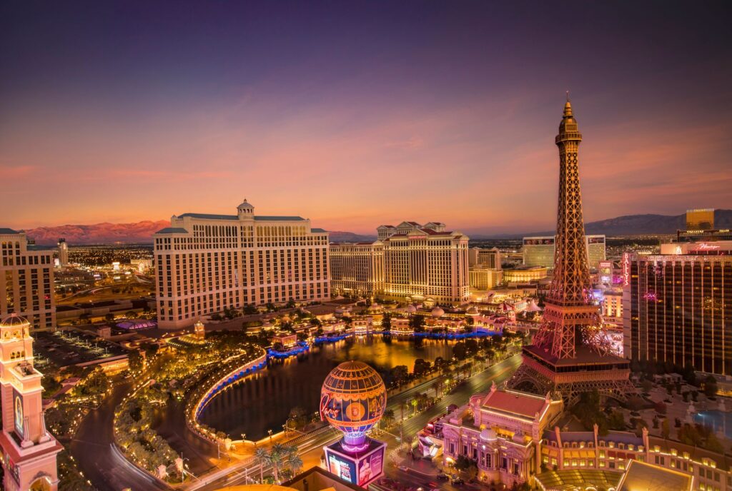 A vibrant photo of the Las Vegas Strip illuminated at night during summer. — best time to visit Las Vegas