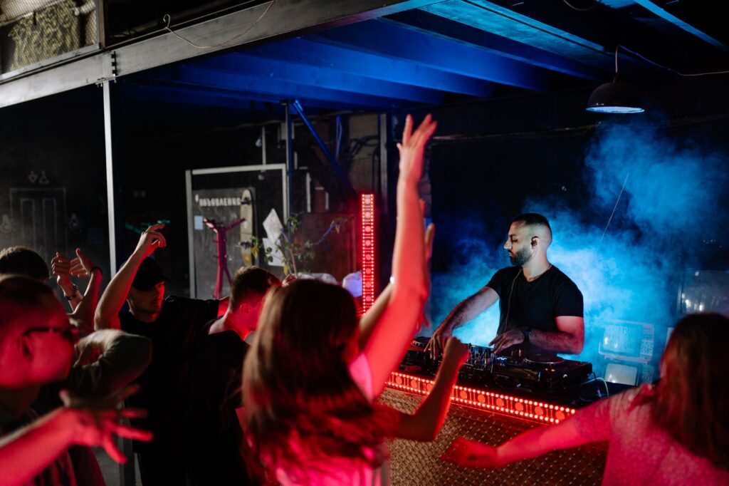 Guests dancing at a pool party with a DJ booth in the background. — Las Vegas pool parties 2026