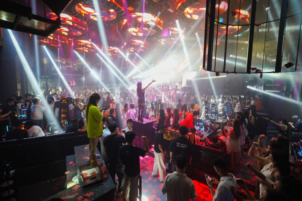 A vibrant view of a popular Las Vegas nightclub with a packed dance floor and DJ booth. — Las Vegas nightlife tips